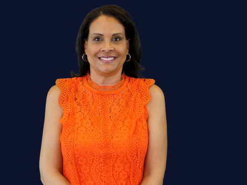 Woman in orange top against navy blue background